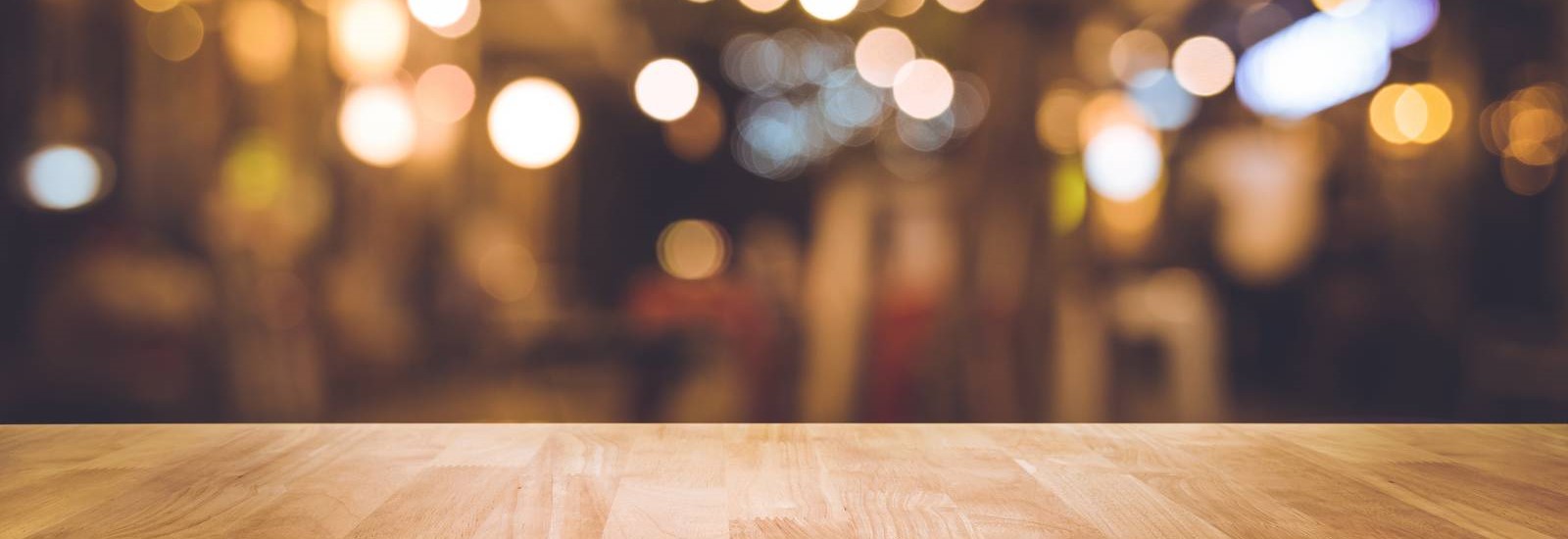 Wood bar table with blur lighting in night street cafe